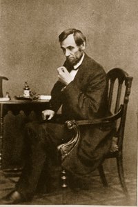 Abraham Lincoln sidder ved et skrivebord i Washington Gallery, maj 1861